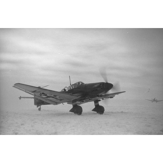 Un bombardier Junkers Ju-87 Stuka du Sturzkampfgeschwader 2 "Immelmann" sur le point de décoller sur un terrain d'aviation enneigé.