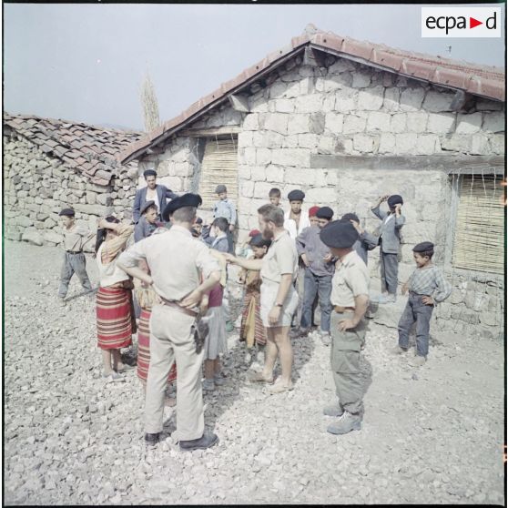 Kabylie. 27e Bataillon de chasseurs alpins (BCA). L'instituteur avec ses élèves devant l'école pour faire un jeu.