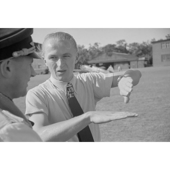Le sous-officier (Oberfeldwebel) Georg Schentke mime à un officier (non identifié) un combat aérien pour les besoins du reportage.