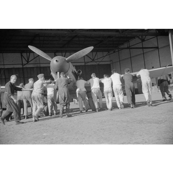 Des mécaniciens du Ergänzungsgruppe Süd positionnent un chasseur Messerschmitt Bf-109 qui porte le numéro 12.