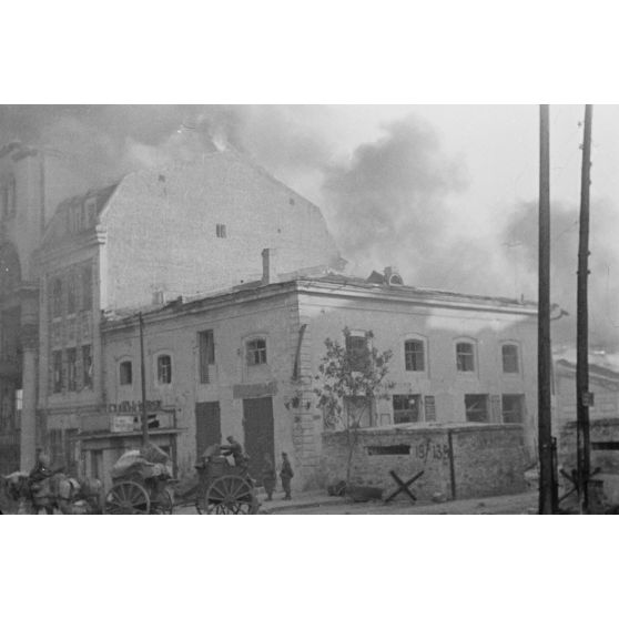 Des soldats chargent une charrette et incendie dans les environs.