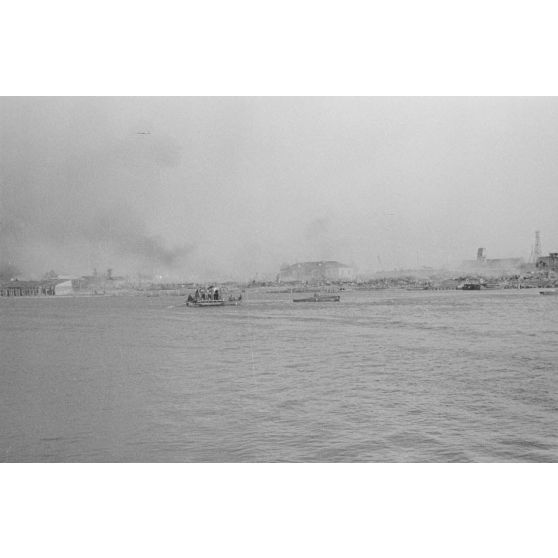 Des soldats et des chevaux traversent le cours d’eau à bord d’une barge.