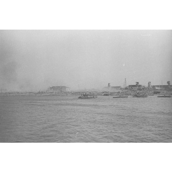 Des soldats et des chevaux traversent le cours d’eau à bord d’une barge.