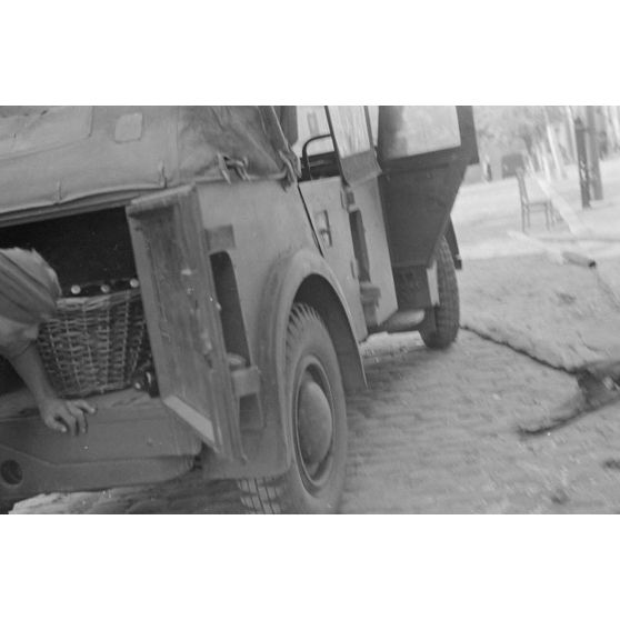 Un soldat charge un coffre de voiture, appartenant à la compagnie de propagande Luftwaffe Z.b.v.