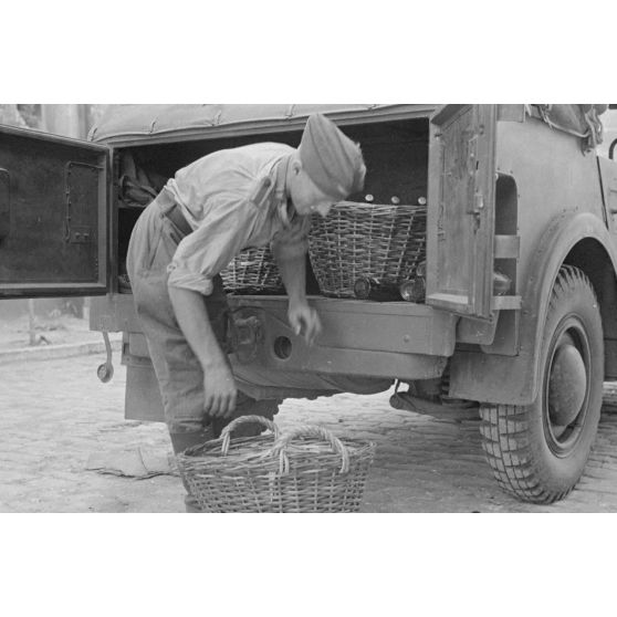 Un soldat charge une voiture, appartenant à la compagnie de propagande Luftwaffe Z.b.v.