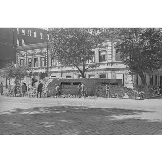 Sous la supervision d’un soldat, un groupe d’hommes détruit une barricade, qui pourrait être Petrovadosk (Carélie, Russie),