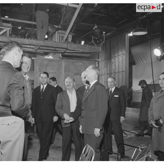 Projection en avant-première aux studios de Boulogne du film Le jour le plus long. Pierre Messmer, ministre des Armées, salue l'acteur John Wayne, en présence du général Pierre Koenig, conseiller militaire du film, et de Darryl Zanuck, producteur du film.