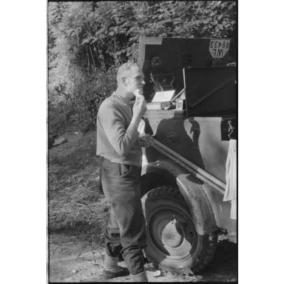 Hygiène du matin, en arrière-plan l'insigne du 2e corps de DCA (II. Flakkorps).