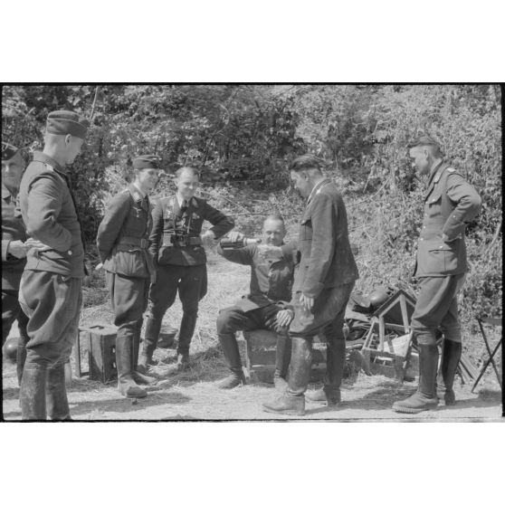 Des officiers de la FlaK et des membres de la Luftwaffe Kriegsberichter Kompanie 4 partagent une bouteille.