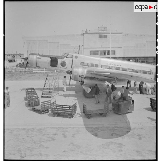 Sur l'aéroport de Marignane, des bagages sont déchargés de l'avion de transport Dewoitine D338 baptisé Ville de Damas, de la compagnie Air France.
