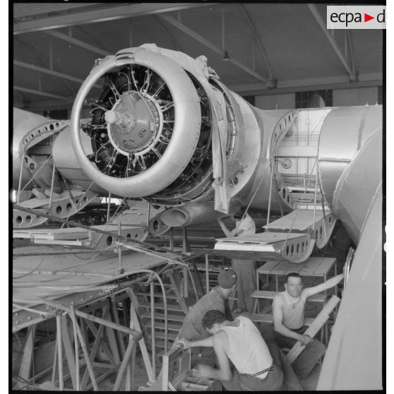 Montage d'un des moteurs d'un hydravion de transport SE 200 de la Société nationale de constructions aéronautiques du Sud-Est (SNCASE), dans un hangar, sur le site de la société à Marignane.
