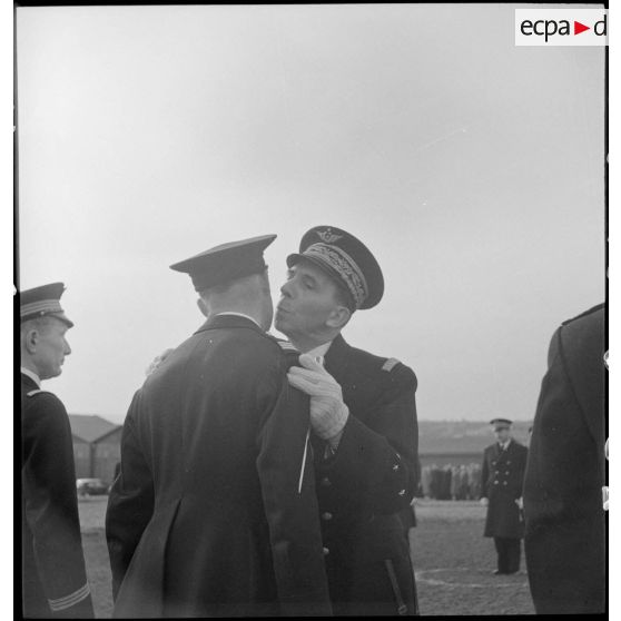 Au cours d'une prise d'armes sur la base aérienne d'Aulnat, un général de corps aérien donne l'accolade à un capitaine après l'avoir décoré.
