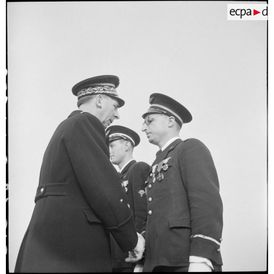 Au cours d'une prise d'armes sur la base aérienne d'Aulnat, un général de corps aérien félicite un adjudant-chef à qui il vient de remettre la médaille militaire.