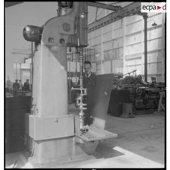 Un ouvrier de l'atelier de réparation de l'armée de l'Air (ARAA) de Limoges usine une pièce de moteur d'avion sur une machine-outil.