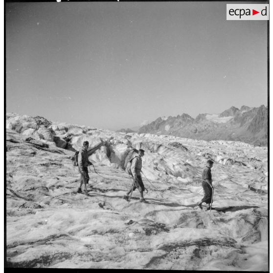 Des jeunes gens, membres du mouvement Jeunesse et Montagne, progressent sur un glacier en cordée lors d'un séjour dans un centre pyrénéen du mouvement.
