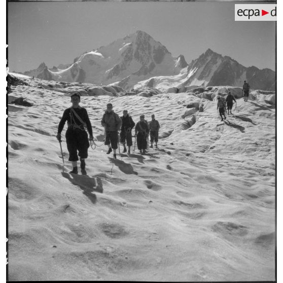 Des jeunes gens, membres du mouvement Jeunesse et Montagne, progressent sur un glacier en cordée lors d'un séjour dans un centre pyrénéen du mouvement.