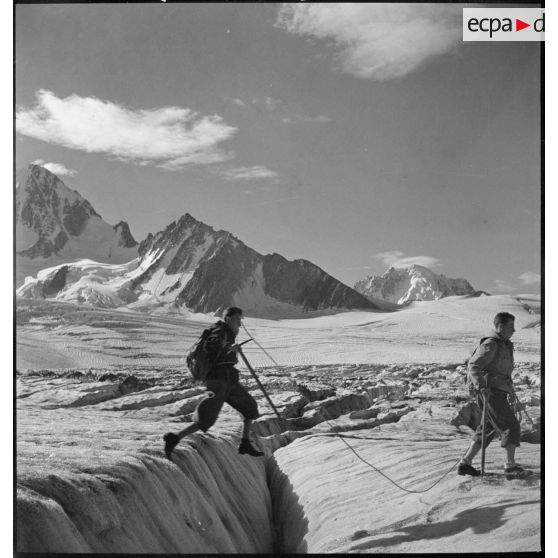 Des jeunes gens, membres du mouvement Jeunesse et Montagne, progressent sur un glacier en cordée lors d'un séjour dans un centre pyrénéen du mouvement.