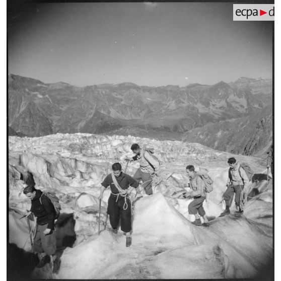 Des jeunes gens, membres du mouvement Jeunesse et Montagne, progressent sur un glacier en cordée lors d'un séjour dans un centre pyrénéen du mouvement.