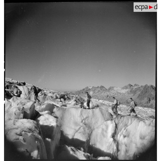 Des jeunes gens, membres du mouvement Jeunesse et Montagne, progressent sur un glacier en cordée lors d'un séjour dans un centre pyrénéen du mouvement.