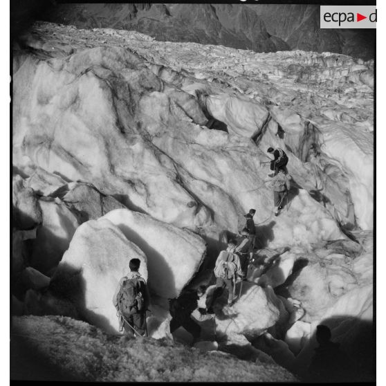 Des jeunes gens, membres du mouvement Jeunesse et Montagne, progressent sur un glacier en cordée lors d'un séjour dans un centre pyrénéen du mouvement.