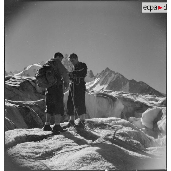Des jeunes gens, membres du mouvement Jeunesse et Montagne, progressent sur un glacier en cordée lors d'un séjour dans un centre pyrénéen du mouvement.