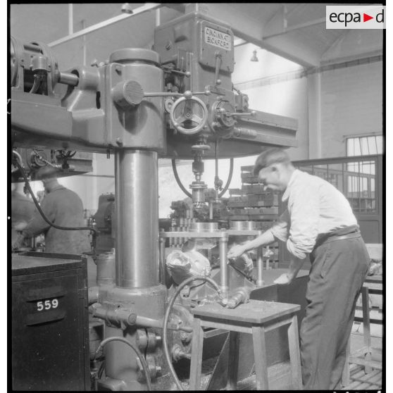 Un ouvrier de l'atelier de réparation de l'armée de l'Air (ARAA) de Limoges usine des pièces de moteurs d'avions sur une machine-outil.