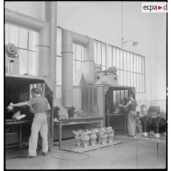 Des ouvriers de l'atelier de réparation de l'armée de l'Air (ARAA) de Limoges peignent des pièces de moteurs d'avions avant assemblage.