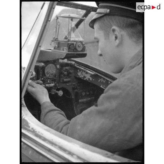 Instruction dans le poste de pilotage d'un avion de chasse Bloch MB 152 à l'école de formation des mécaniciens-radios de l'armée de l'Air sur la base aérienne de Chambéry.