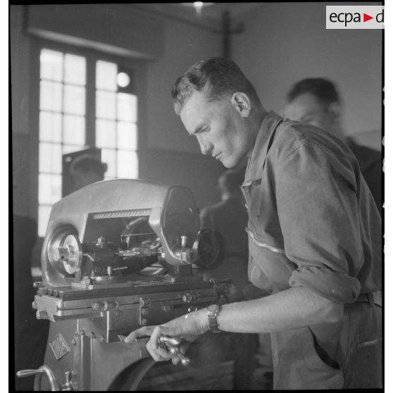 Utilisation d'une machine-outil à l'école de formation des mécaniciens-radios de l'armée de l'Air sur la base aérienne de Chambéry.
