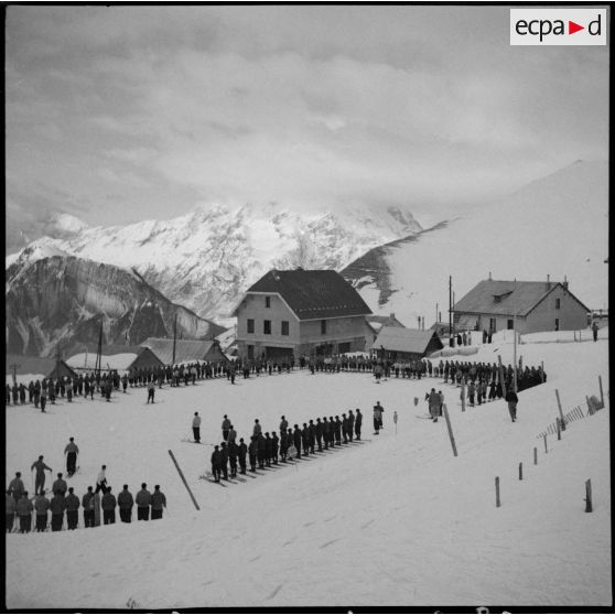 Des engagés de l'armée de l'Air démobilisés et des jeunes volontaires de l'organisation Jeunesse et Montagne sont rassemblés pour participer aux épreuves d'un concours de ski.