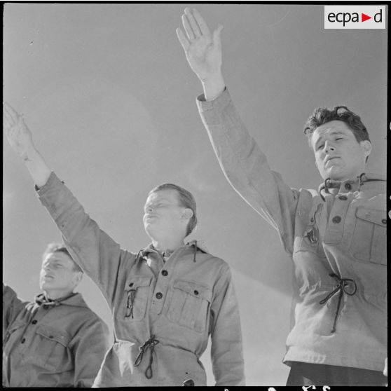 Salut et prestation de serment des équipes participantes avant un concours de ski de l'organisation Jeunesse et Montagne dans les Alpes.