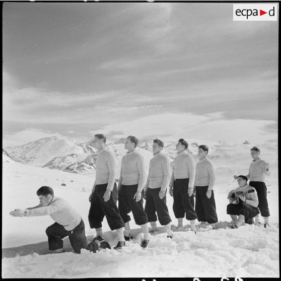 Jeunes volontaires participant à une activité artistique avant un concours de ski de l'organisation Jeunesse et Montagne dans les Alpes.