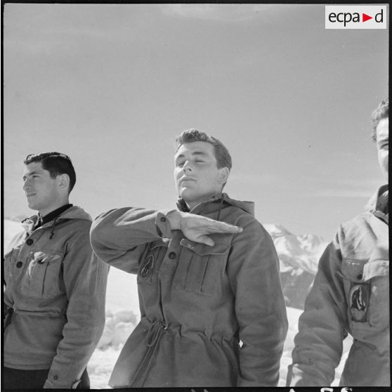 Salut d'un volontaire d'une équipe participante avant un concours de ski de l'organisation Jeunesse et Montagne dans les Alpes.