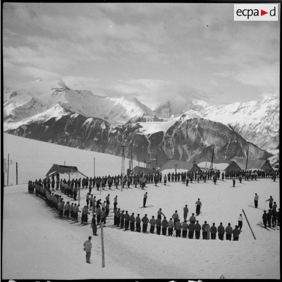 Des engagés de l'armée de l'Air démobilisés et des jeunes volontaires de l'organisation Jeunesse et Montagne sont rassemblés pour participer aux épreuves d'un concours de ski.