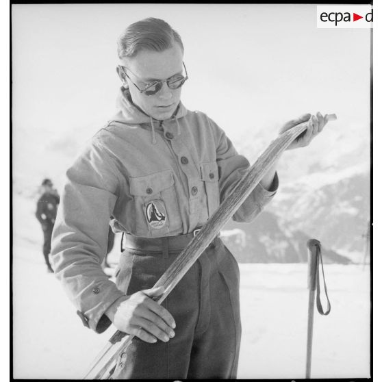 Portrait d'un volontaire participant avant un concours de ski de l'organisation Jeunesse et Montagne dans les Alpes.