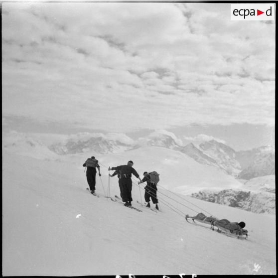 Epreuve de brancardage d'un blessé lors d'un concours de l'organisation Jeunesse et Montagne dans les Alpes.