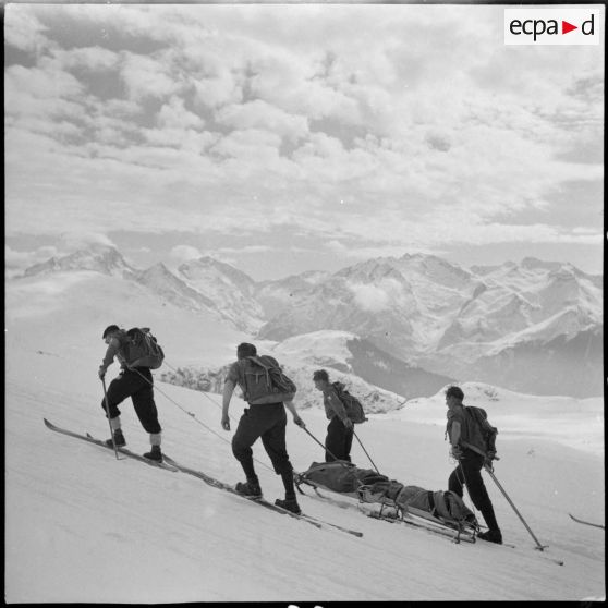 Epreuve de brancardage d'un blessé lors d'un concours de l'organisation Jeunesse et Montagne dans les Alpes.