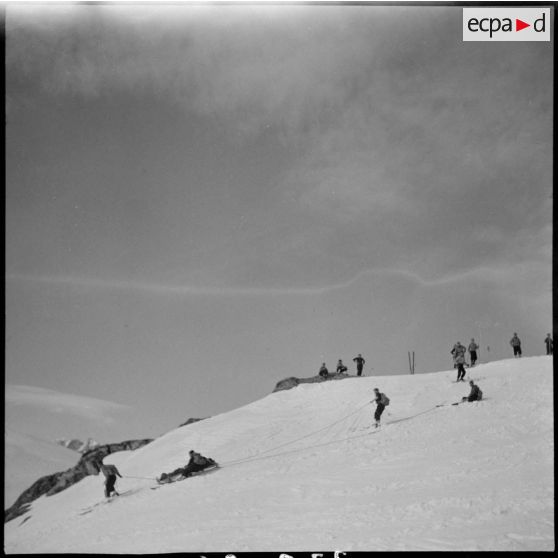 Epreuve de brancardage d'un blessé lors d'un concours de l'organisation Jeunesse et Montagne dans les Alpes.