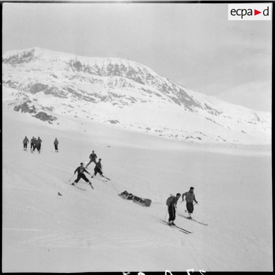 Epreuve de brancardage d'un blessé lors d'un concours de l'organisation Jeunesse et Montagne dans les Alpes.