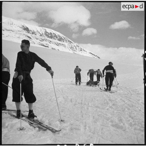 Epreuve de brancardage d'un blessé lors d'un concours de l'organisation Jeunesse et Montagne dans les Alpes.