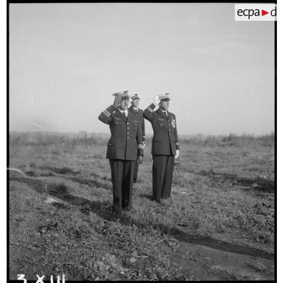 Le colonel qui préside la prise d'armes sur l'aérodrome de Vichy-Rhue salue les personnels rassemblés.