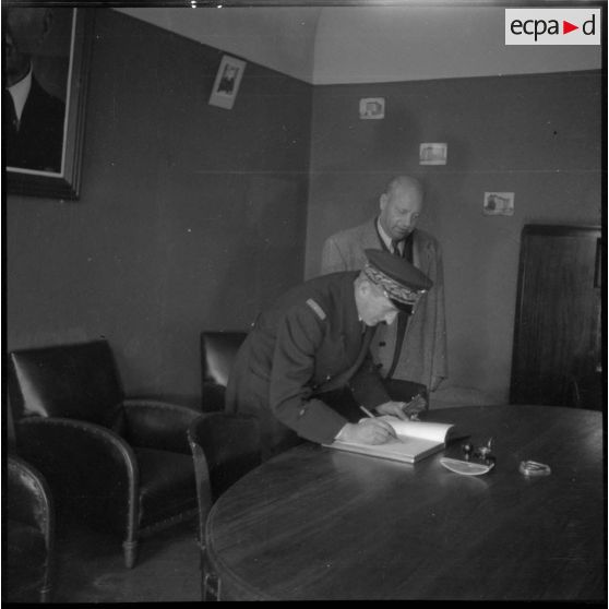 Lors d'une visite à l'Ecole des pupilles de l'Air (EPA) à Grenoble, le général de brigade aérienne Jean-Marie Bergeret, secrétaire d'Etat à l'Aviation, signe un livre d'or.