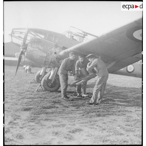 Mise en place des nacelles de mitrailleuses sous la voilure d'un avion d'observation Potez 63-11 avant un départ en mission.