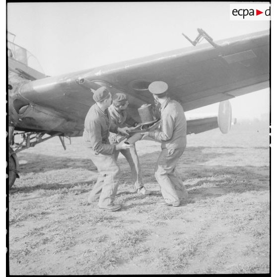 Mise en place de nacelles de mitrailleuses sous une aile d'un avion d'observation Potez 63-11 avant un départ en mission.