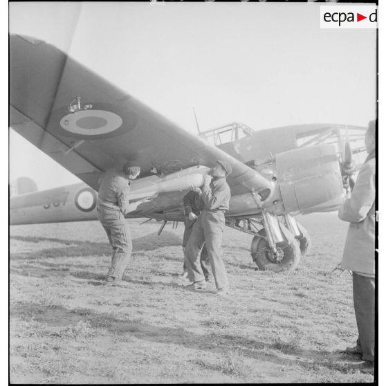 Mise en place de bombes sous la voilure d'un avion d'observation Potez 63-11 avant un départ en mission.