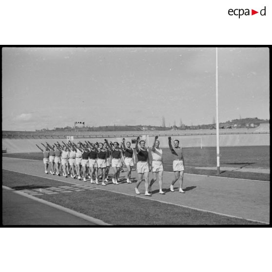 Salut olympique des athlètes qui défilent sur le stade de Vichy lors d'une manifestation sportive rassemblant des unités de l'armée de l'Air.