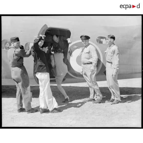 M. Fernand Grenier, commissaire à l'Air, embarque dans son avion de transport avec les gagnants de la tombola sur les terrains de Réghaia.