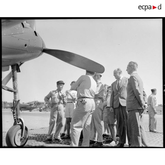 Le commandant de la Martinière donne des renseignements techniques aux jeunes de l'aviation sur le terrain de Réghaia devant un Airacobra.