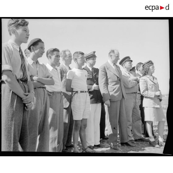 M. Grenier ainsi que le général Bouscat et les gagnants du tirage de la tombola admirent les acrobaties d'un chasseur sur le terrain de Réghaia.