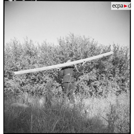 Homme portant un débris de l'avion accidenté à Fez.